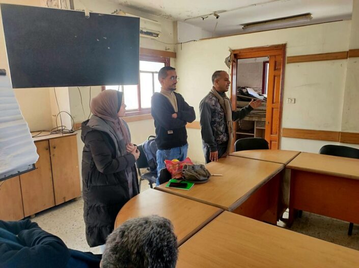 ثلاثة أشخاص يقفون في قاعة التدريب بينما يتحدث أحدهم إلى المشاركين